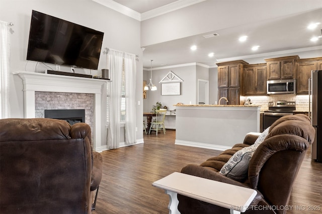 living area featuring visible vents, a fireplace, ornamental molding, and dark wood finished floors