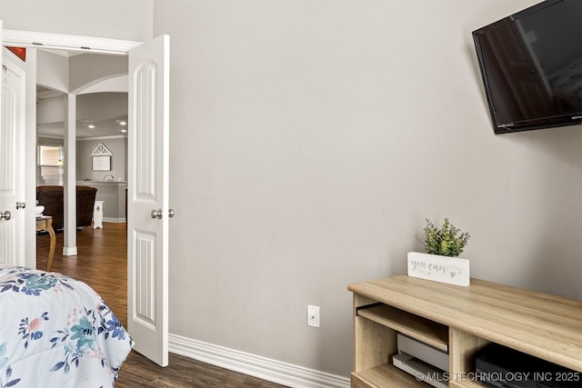 bedroom with dark wood-style floors and baseboards