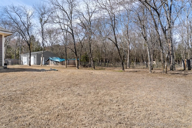 view of yard with a garage and an outbuilding