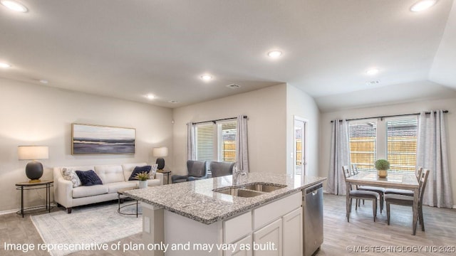 kitchen featuring a center island with sink, stainless steel dishwasher, open floor plan, white cabinets, and a sink