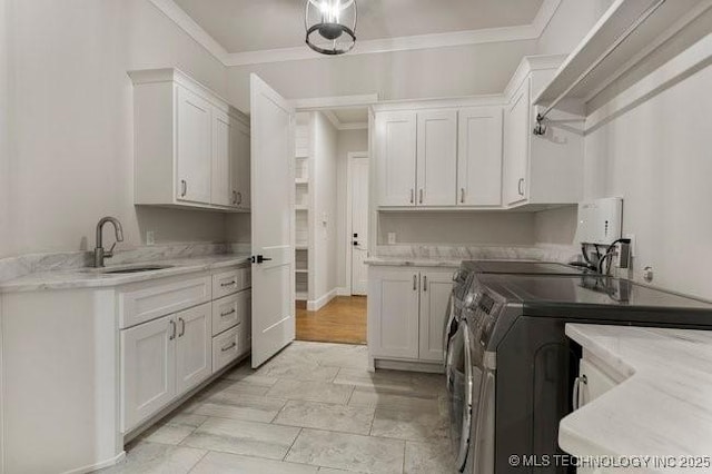 11904 S Toledo Ave, Tulsa, OK 74137 - laundry room with crown molding, cabinet space, a sink, and separate washer and dryer
