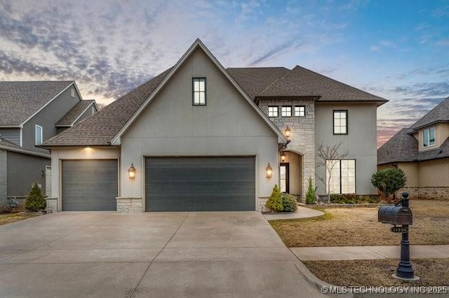 french country style house featuring a garage, stone siding, concrete driveway, and stucco siding