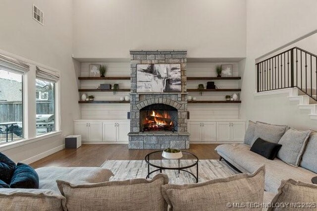 11904 S Toledo Ave, Tulsa, OK 74137 - living room with a stone fireplace, wood finished floors, a towering ceiling, visible vents, and stairway