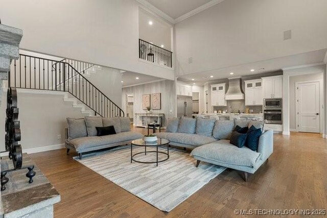 11904 S Toledo Ave, Tulsa, OK 74137 - living room with baseboards, ornamental molding, wood finished floors, a high ceiling, and stairs