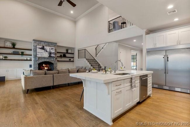 11904 S Toledo Ave, Tulsa, OK 74137 - kitchen with white cabinetry, open floor plan, light countertops, appliances with stainless steel finishes, and a center island with sink