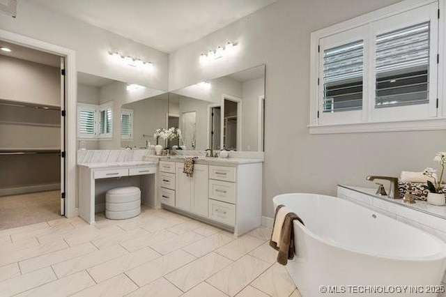11904 S Toledo Ave, Tulsa, OK 74137 - full bath featuring a freestanding bath, a spacious closet, vanity, and baseboards