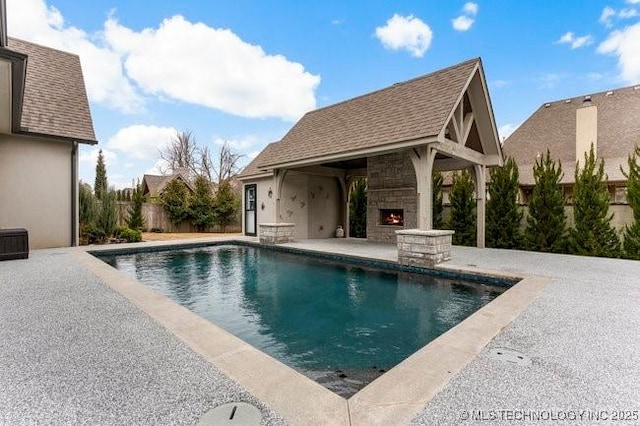 11904 S Toledo Ave, Tulsa, OK 74137 - view of swimming pool featuring a patio area, a lit fireplace, fence, and a fenced in pool