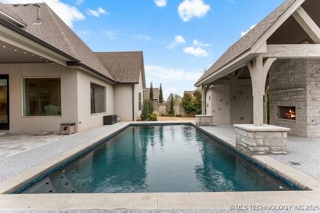 11904 S Toledo Ave, Tulsa, OK 74137 - view of swimming pool featuring a warm lit fireplace, a fenced in pool, and a patio
