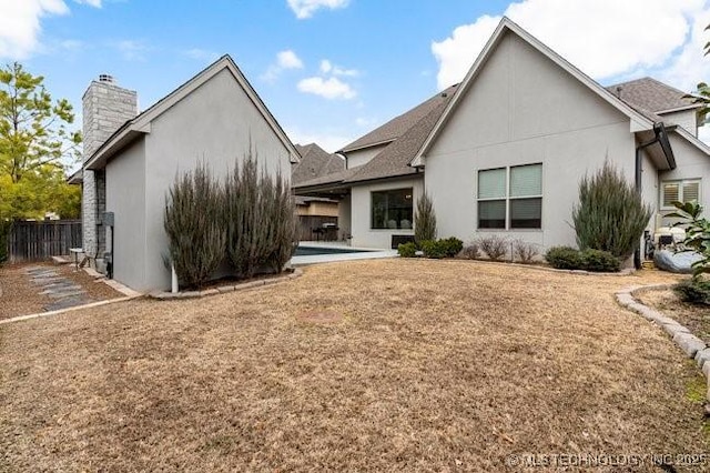 11904 S Toledo Ave, Tulsa, OK 74137 - back of property with fence, a chimney, and stucco siding