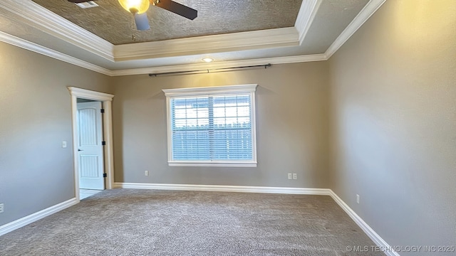 empty room featuring a tray ceiling, carpet flooring, and baseboards