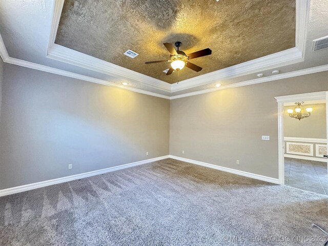 spare room with visible vents, a tray ceiling, carpet flooring, and ceiling fan with notable chandelier