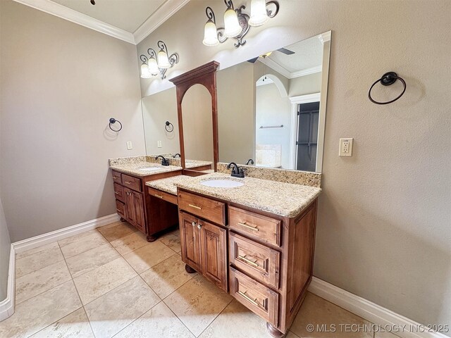 full bath with ornamental molding, two vanities, a sink, and baseboards