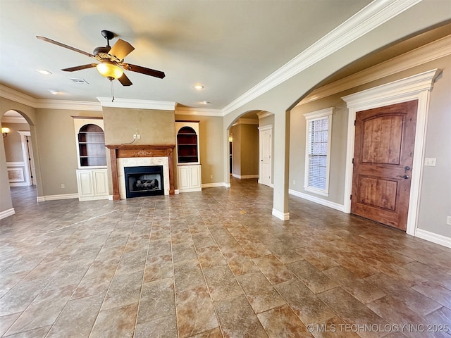 unfurnished living room featuring crown molding, visible vents, a premium fireplace, a ceiling fan, and baseboards