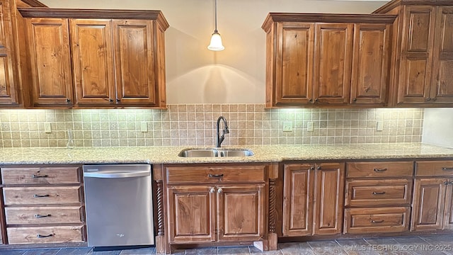 kitchen featuring dishwasher, a sink, and light stone countertops