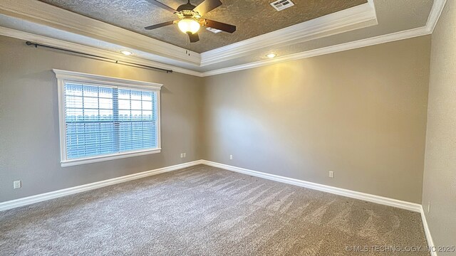 carpeted spare room with crown molding, a raised ceiling, visible vents, a textured ceiling, and baseboards