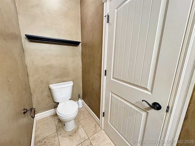 bathroom featuring toilet, baseboards, and tile patterned floors