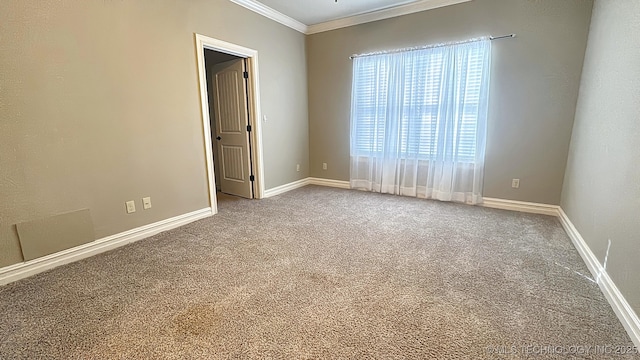 carpeted spare room featuring crown molding and baseboards