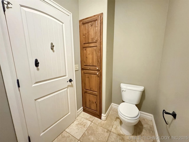 bathroom featuring tile patterned floors, toilet, and baseboards