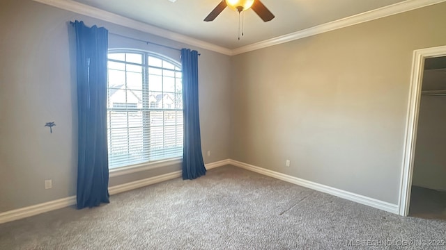 carpeted spare room with ornamental molding, ceiling fan, and baseboards