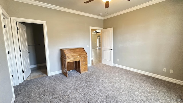 unfurnished bedroom featuring a spacious closet, ornamental molding, carpet flooring, and baseboards