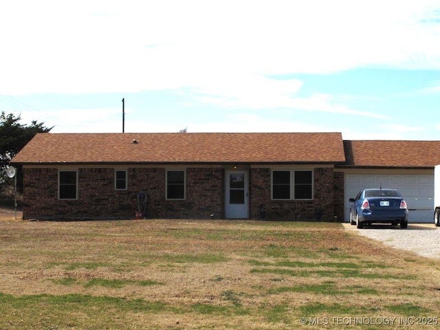 single story home with driveway, an attached garage, and a front yard