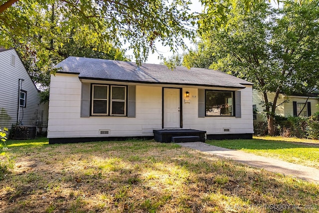 view of front of property featuring roof with shingles, central AC unit, crawl space, and a front yard