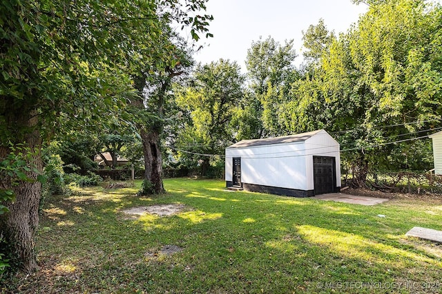 view of yard featuring a detached garage and an outbuilding