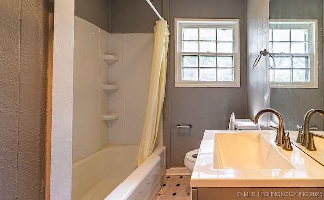 bathroom with toilet, shower / bath combination with curtain, and a sink