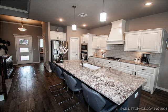 190 N Castle St, Skiatook, OK 74070 - kitchen with custom exhaust hood, stainless steel appliances, tasteful backsplash, dark wood-style flooring, and white cabinets