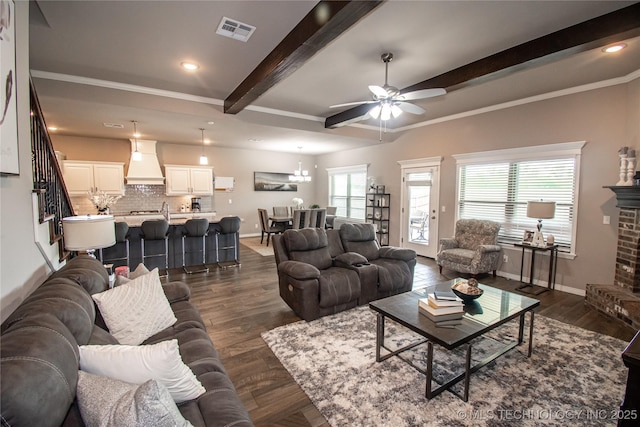 190 N Castle St, Skiatook, OK 74070 - living area featuring beam ceiling, ceiling fan, dark wood-style floors, crown molding, and a brick fireplace