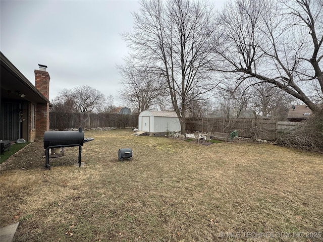 view of yard featuring an outbuilding, fence, and a storage shed