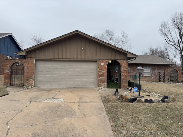 single story home featuring a garage, roof with shingles, concrete driveway, and brick siding