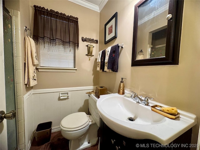 bathroom featuring toilet, a wainscoted wall, ornamental molding, and vanity