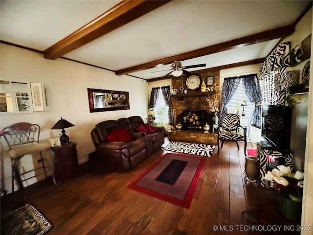 living room with ceiling fan, a fireplace, wood finished floors, and beam ceiling