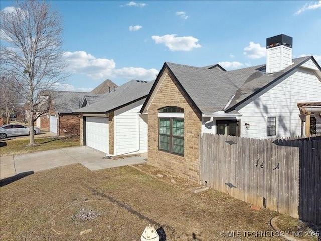 view of property exterior with an attached garage, brick siding, fence, a yard, and concrete driveway