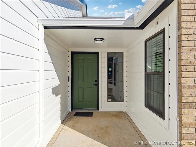 view of exterior entry with brick siding