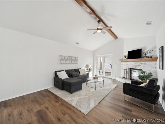 living area featuring wood finished floors, visible vents, baseboards, beam ceiling, and a glass covered fireplace