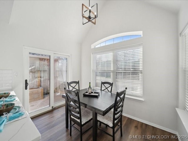 dining room with a chandelier, high vaulted ceiling, dark wood finished floors, and baseboards