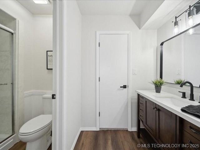 full bathroom with toilet, a shower stall, wood finished floors, and vanity