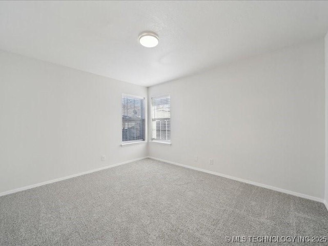 unfurnished room featuring carpet floors and baseboards