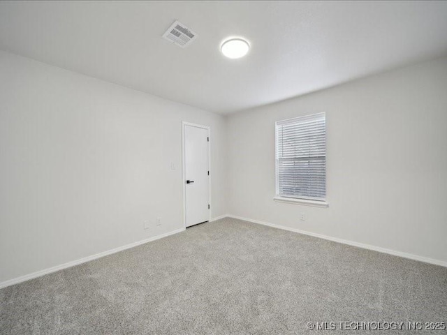 carpeted empty room featuring visible vents and baseboards