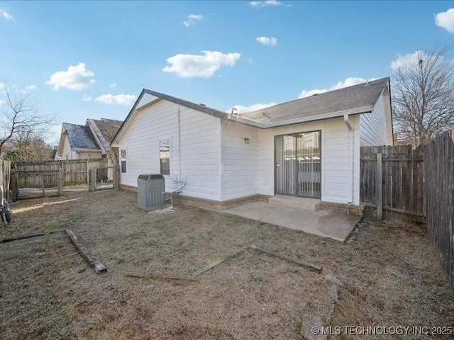 rear view of property with a patio area, a fenced backyard, and central AC