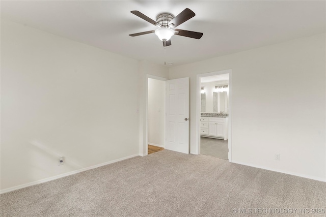 unfurnished bedroom with ensuite bath, baseboards, a ceiling fan, and light colored carpet