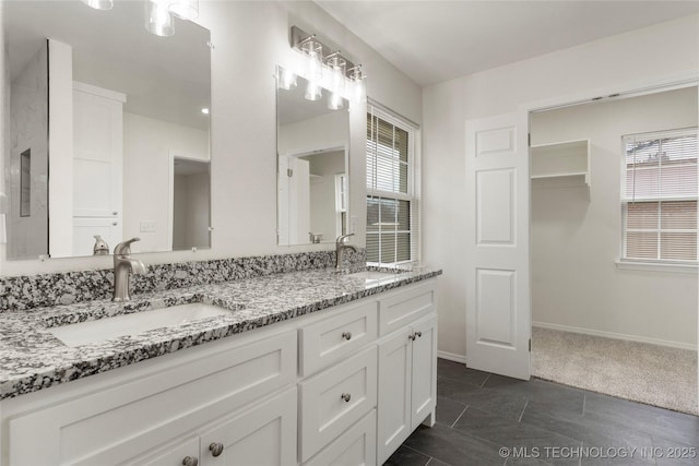 bathroom featuring a healthy amount of sunlight, double vanity, and a sink