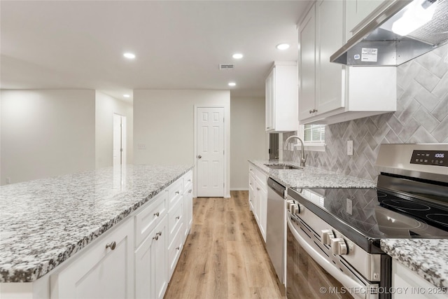 kitchen featuring visible vents, appliances with stainless steel finishes, white cabinets, a sink, and under cabinet range hood