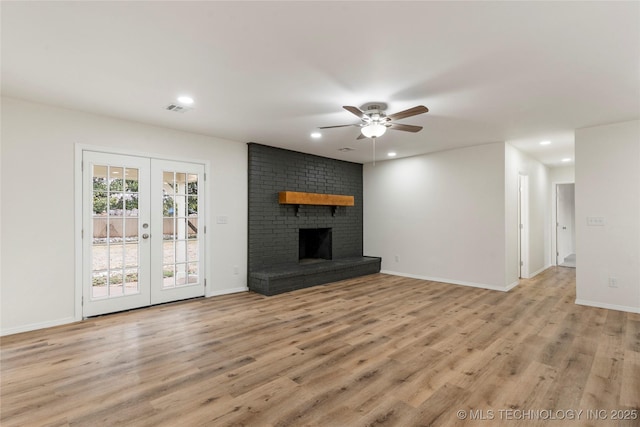 unfurnished living room featuring french doors, recessed lighting, visible vents, light wood-style floors, and a brick fireplace