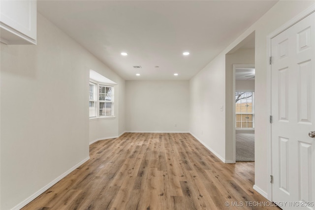 empty room with light wood-type flooring, visible vents, baseboards, and recessed lighting