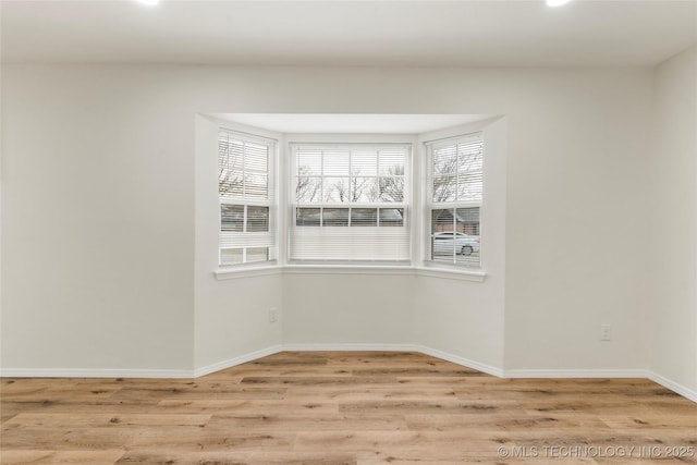 unfurnished room featuring light wood finished floors and baseboards