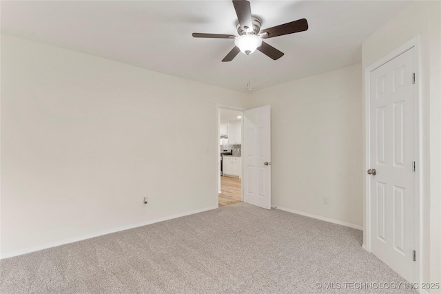 unfurnished bedroom with light carpet, ceiling fan, and baseboards