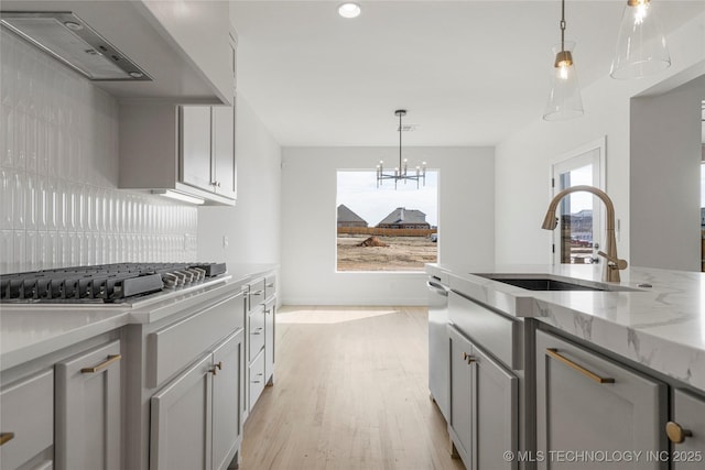 2038 E 129th St, Jenks, OK 74037 - kitchen with stainless steel gas cooktop, light wood-type flooring, light stone counters, a chandelier, and pendant lighting